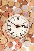 a clock surrounded by coins photo