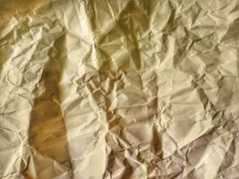 Yellow wrinkled paper texture or background photo