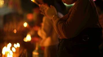 Asian people lighting candles to paying homage Buddha in temple to make a wish on the traditional Songkran festival in Thailand. video