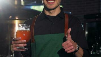 Unrecognizable brewer in apron showing thumbs up, holding glass of beer video