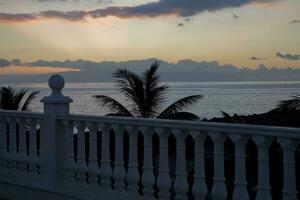 picturesque ocean landscape with the setting sun in a tropical country during summer holidays with palm photo