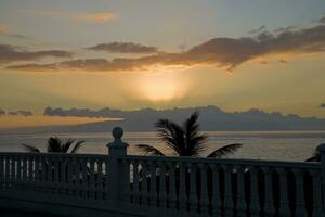 picturesque ocean landscape with the setting sun in a tropical country during summer holidays with palm photo