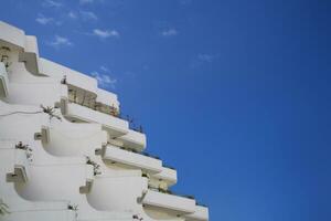 white building with balconies against a blue cloudless sky on a warm sunny day photo