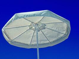 artful background with umbrellas against the backdrop of a blue cloudless sky on a hot summer day at the beach photo