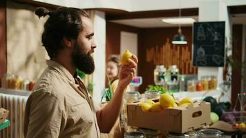 Man in bio supermarket shops for farm grown fruits, getting dopamine rush while smelling them. Customer experiences bliss while feeling nice lemons aroma in eco friendly food shop, zoom in shot video