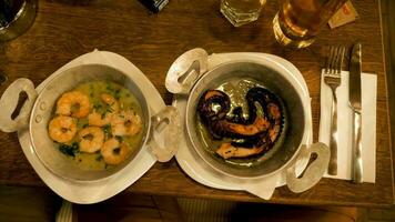 twee borden met fijnproever en heerlijk zeevruchten gemaakt van gebakken Octopus en garnalen video
