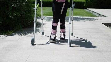 child with walking frame and knee orthosis outdoor video