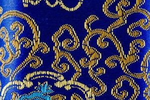 a blue and gold patterned fabric with a cat on it photo