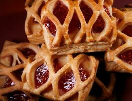 Puff pastry pastry with lingonberry jam on a dark red background. Cookies with lingonberry jam. photo