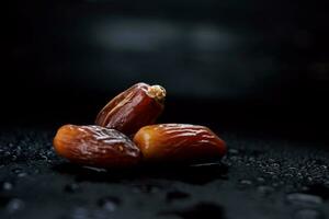 Several ripe dates on a black background. Delicious dates on black. photo