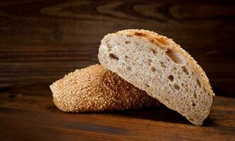 Cut loaf of bread and pieces of bread on a wooden background. Ciabatta bread. photo
