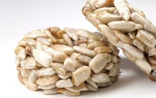 Kozinaki from sunflower seeds on a white background. Round kozinaki. photo