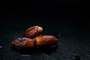 Several ripe dates on a black background. Delicious dates on black. photo