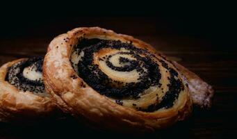 Two delicious buns with poppy seeds on a dark background. photo