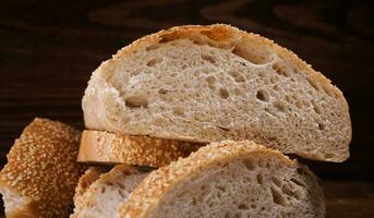 ciabatta un pan. rebanado piezas de un pan en un de madera antecedentes. foto