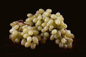 A bunch of green grapes on a dark background. photo