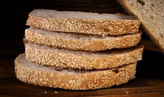 ciabatta un pan. rebanado piezas de un pan en un de madera antecedentes. foto