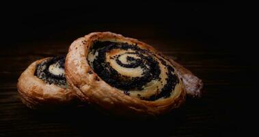 Two delicious buns with poppy seeds on a dark background. photo