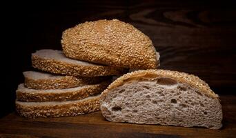 Cut loaf of bread and pieces of bread on a wooden background. Ciabatta bread. photo