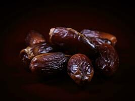 Several ripe dates on a dark red background. Delicious dates on red. photo