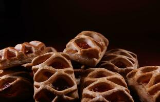 soplo Pastelería Pastelería con arándano rojo mermelada en un oscuro rojo antecedentes. galletas con arándano rojo mermelada. foto