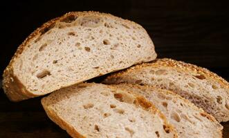 cortar pan de un pan y piezas de un pan en un de madera antecedentes. ciabatta un pan. foto