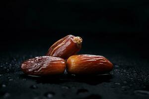 Several ripe dates on a black background. Delicious dates on black. photo