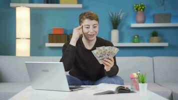 Looking at the money in his hand, a student comes up with an idea. video