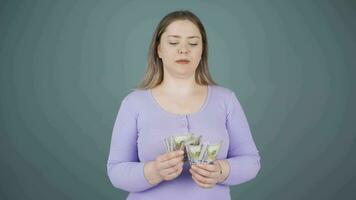 Woman counting money looking at camera. video