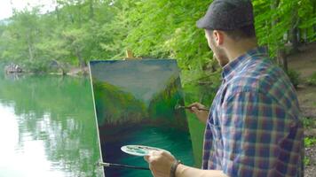 Painter paints landscape in nature. video