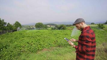 Farmer using tablet looks at his field. video