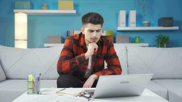 Young man reading messages, mail, news from laptop, nods his head positively. video