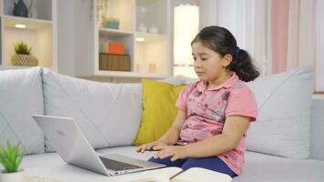 Girl child looking at laptop in amazement. video