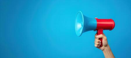 Generative AI, megaphone in hand on a empty blue background, panoramic image with copy space photo