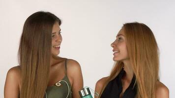twee mooi vrouw vrienden glimlachen naar de camera, poseren in training kleding video