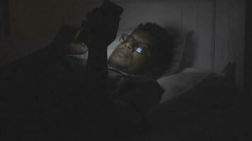 jovem homem usando inteligente telefone às noite em cama video