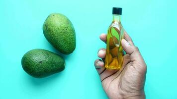 oil and slice of avocado on light green background video