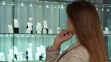 Young female customer smiling, choosing jewels for sale at the luxury store video