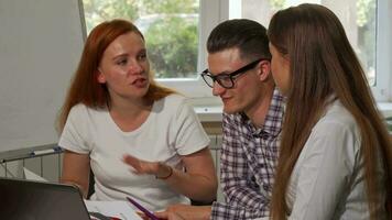 Group of young businesspeople smiling to the camera while working together video