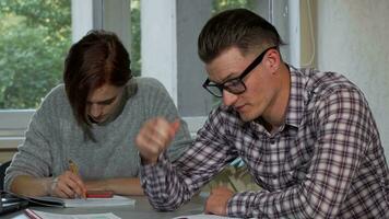 Male student taking off his glasses, looking tired while studying video