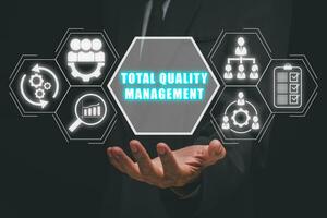 Total quality management concept, Businessman hand holding total quality management icon on virtual screen. photo