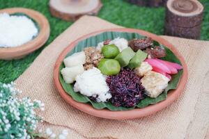 Jenang Madura is a typical Indonesian food that consists of black sticky rice, porridge marrow, jenang grendul and red pearls that were given palm sugar and coconut milk photo