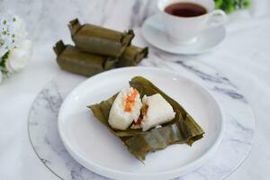 Arem-arem, a traditional food made from rice filled with vegetables, chicken, meat or tempeh wrapped in banana leaves. Arem-arem is popular as a breakfast substitute photo
