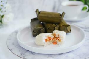 Arem-arem, a traditional food made from rice filled with vegetables, chicken, meat or tempeh wrapped in banana leaves. Arem-arem is popular as a breakfast substitute photo