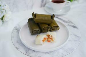 Arem-arem, a traditional food made from rice filled with vegetables, chicken, meat or tempeh wrapped in banana leaves. Arem-arem is popular as a breakfast substitute photo