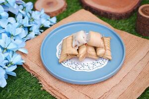Lepet or Leupeut is a type of snack made from glutinous rice mixed with peanuts, cooked in coconut milk, then wrapped in coconut leaves. Close up view photo