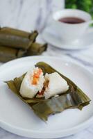 Arem-arem, a traditional food made from rice filled with vegetables, chicken, meat or tempeh wrapped in banana leaves. Arem-arem is popular as a breakfast substitute photo
