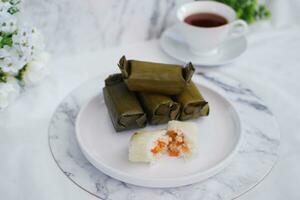 Arem-arem, a traditional food made from rice filled with vegetables, chicken, meat or tempeh wrapped in banana leaves. Arem-arem is popular as a breakfast substitute photo