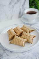 Lepet or Leupeut is a type of snack made from glutinous rice mixed with peanuts, cooked in coconut milk, then wrapped in coconut leaves. Close up view photo