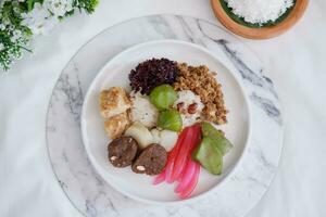 Jenang Madura is a typical Indonesian food that consists of black sticky rice, porridge marrow, jenang grendul and red pearls that were given palm sugar and coconut milk photo